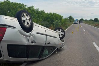 Autoturism răsturnat pe pavilion pe șoseaua DJ 593 la intrarea în localitatea Peciu Nou în urma coliziunii cu un atelaj hipo.