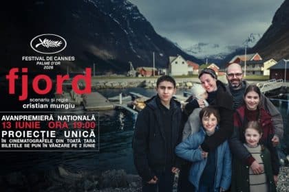 Regizorul român Cristian Mungiu pe covorul roșu de la Festivalul de Film de la Cannes ținând în mână trofeul Palme d’Or.
