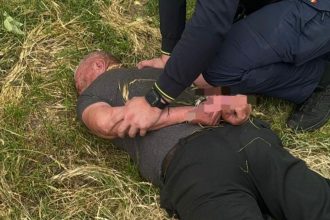 Autospecială de poliție cu semnalele acustice și luminoase pornite pe un drum de țară din județul Hunedoara în timpul unei intervenții.