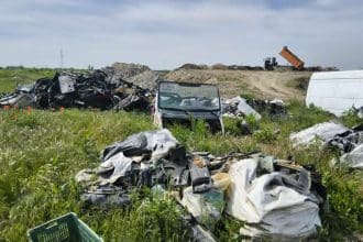 Polițiști locali din cadrul Serviciului Protecția Mediului inspectând o rampă ilegală de deșeuri pe domeniul public.