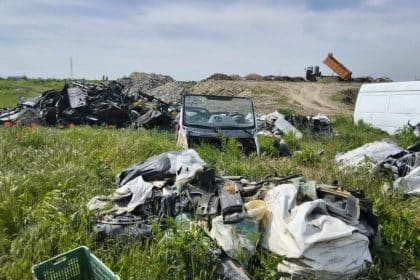 Polițiști locali din cadrul Serviciului Protecția Mediului inspectând o rampă ilegală de deșeuri pe domeniul public.