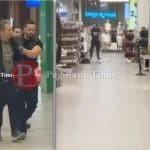 Autospeciale ale Poliției și o ambulanță cu semnalele acustice și luminoase pornite în fața intrării principale a centrului comercial.