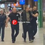 Agresorul în vârstă de 50 de ani flancat de polițiști și mascați la intrarea în sediul Parchetului pentru audieri.
