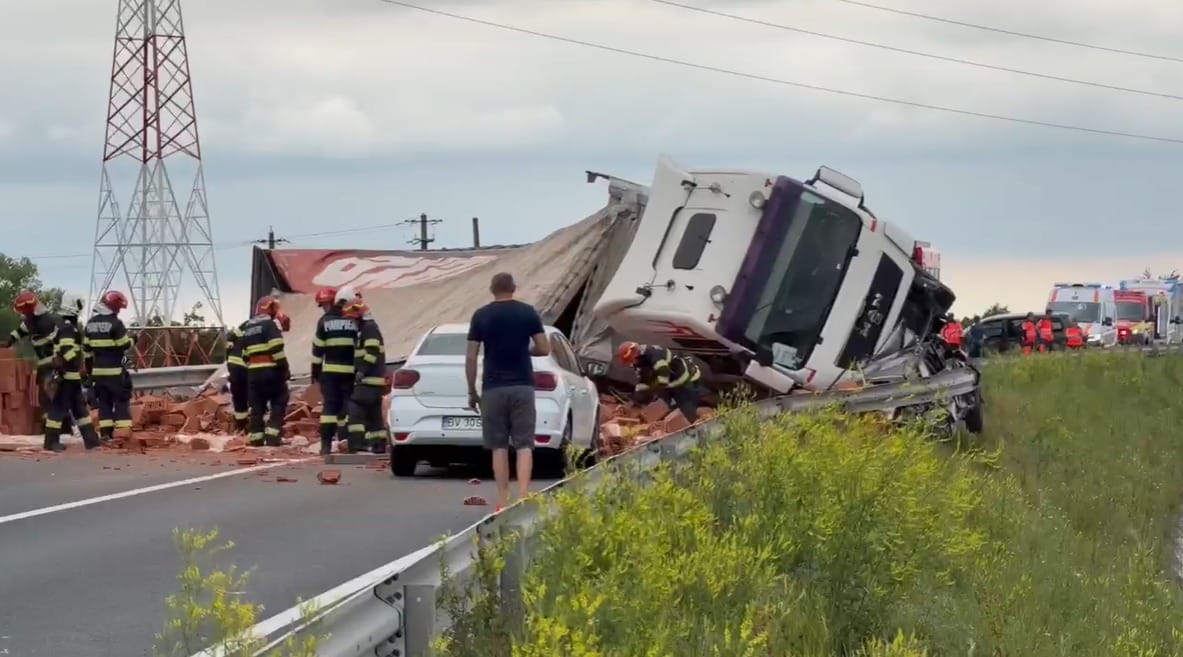 Echipaje de descarcerare ale pompierilor militari acționând la locul unui accident rutier unde un TIR cu semiremorcă s-a răsturnat pe șosea.