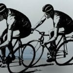 Grup de cicliști în timpul unei curse pe un drum național flancat de echipaje de însoțire ale poliției.
