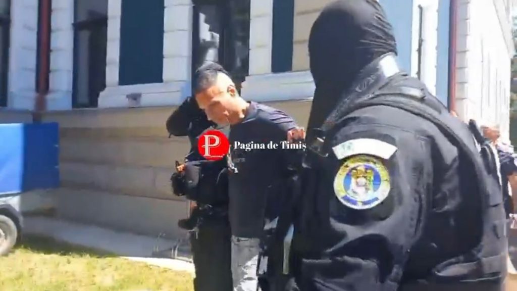 Suspectul George Râță flancat de luptători din cadrul Serviciului pentru Acțiuni Speciale la intrarea în Tribunalul Hunedoara.