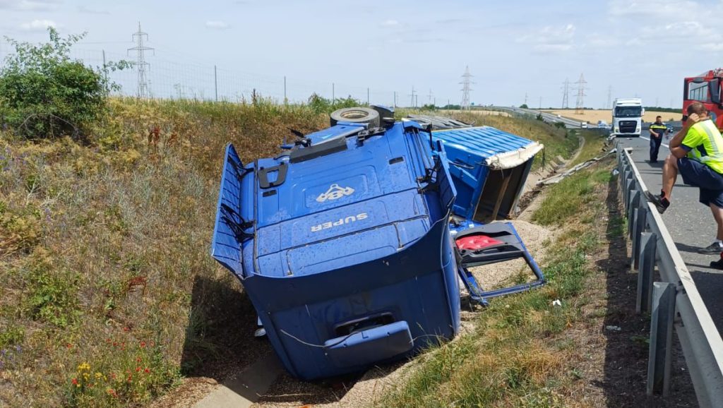 Autotren încărcat cu nisip răsturnat în șanțul de pe marginea autostrăzii A1 între Arad și Timișoara, cu cabina grav distrusă.