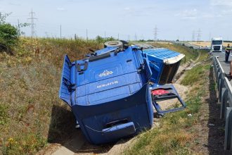 Autotren încărcat cu nisip răsturnat în șanțul de pe marginea autostrăzii A1 între Arad și Timișoara, cu cabina grav distrusă.