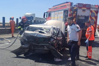 Autoturism cu partea frontală distrusă complet, înfipt în parapetul metalic de protecție de pe autostrada A1, în zona localității Șagu.