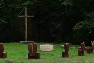 Mobilier din lemn masiv format din masă și bănci rustice, instalat ca punct de odihnă pe marginea traseului turistic Transluncani.