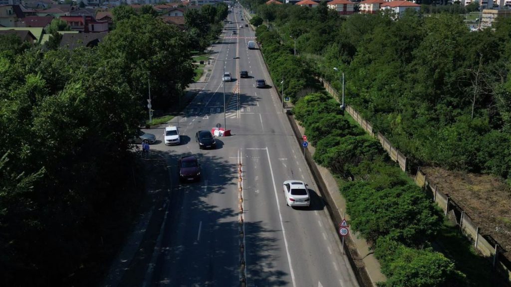 Utilaje de asfaltare și muncitori pe șantierul noului sens giratoriu de pe drumul județean care leagă Timișoara de comuna Giroc.