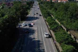 Utilaje de asfaltare și muncitori pe șantierul noului sens giratoriu de pe drumul județean care leagă Timișoara de comuna Giroc.