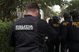 Mascați din trupele speciale ale Poliției Române asigurând perimetrul în timpul perchezițiilor dintr-un dosar de trafic de droguri în Timișoara.