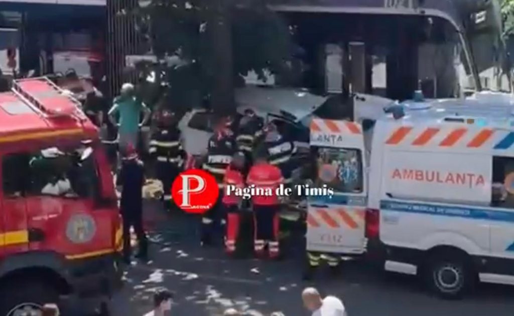 Pompierii militari ISU Banat utilizând echipamente de descarcerare pentru a extrage un taximetrist din mașina lovită de tramvai în fața Consiliului Județean Timiș.