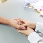 Voluntar al Direcției de Asistență Socială Timișoara livrând baxuri de apă și pachete cu alimente la ușa unei persoane în vârstă, pe timp de caniculă.