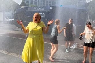 Cetățeni adăpostindu-se la umbră pe o stradă din Timișoara, în timpul codului roșu de caniculă ce aduce temperaturi de 41 de grade Celsius.