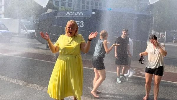 Cetățeni adăpostindu-se la umbră pe o stradă din Timișoara, în timpul codului roșu de caniculă ce aduce temperaturi de 41 de grade Celsius.