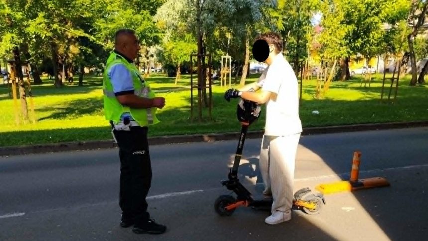 Polițiști locali în Timișoara opgând un trotinetist în trafic pentru verificări și aplicarea de amenzi.