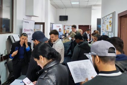 Persoane analizând listele cu locuri de muncă vacante la sediul Agenției pentru Ocuparea Forței de Muncă.