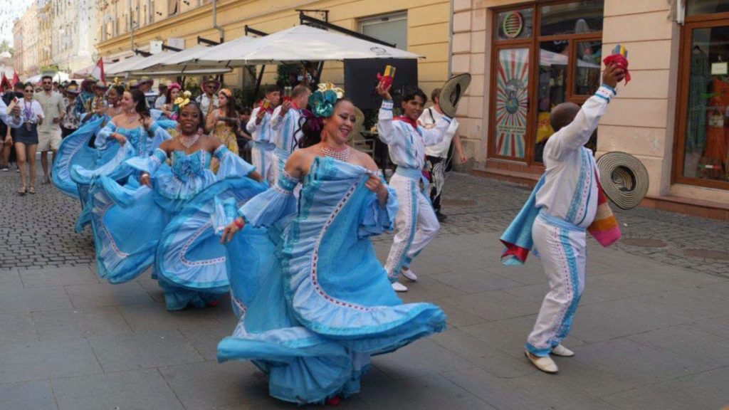 Dansatori în costume populare tradiționale evoluând pe scena Teatrului de Vară din Parcul Rozelor în deschiderea Festivalului Inimilor.