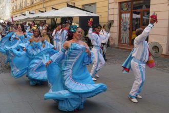 Dansatori în costume populare tradiționale evoluând pe scena Teatrului de Vară din Parcul Rozelor în deschiderea Festivalului Inimilor.
