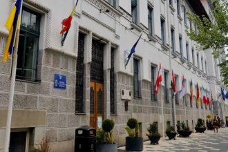 Grup de protestatari adunați în fața clădirii Primăriei Municipiului Timișoara, având pancarte la o acțiune organizată de PUSL.