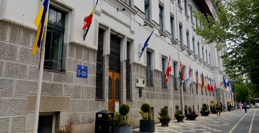 Grup de protestatari adunați în fața clădirii Primăriei Municipiului Timișoara, având pancarte la o acțiune organizată de PUSL.