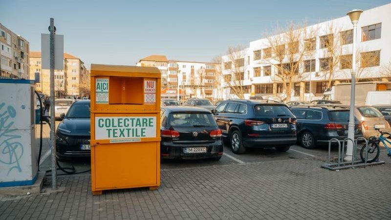 Locuitor din Timișoara introducănd o pungă cu haine vechi într-un container special destinat colectării și reciclării materialelor textile.