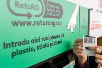Cetățean introducând sticle de plastic și doze de aluminiu într-un aparat automat de colectare SGR pentru recuperarea garanției.