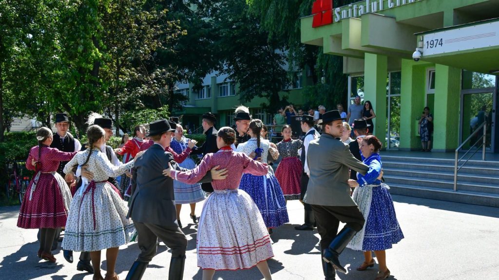Ansamblu folclor în haine tradiționale dansând în curtea Spitalului Județean din Timișoara în cadrul Festivalului Inimilor.