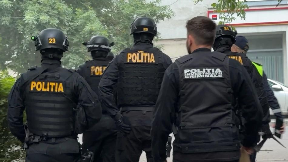 Polițiști din cadrul BCCO Timișoara și mascați în timpul unor percheziții la un traficant de droguri.