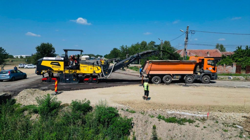 Lucrări de infrastructură rutieră și utilaje pe drumul județean Timișoara-Buziaș pentru construcția a două noi sensuri giratorii.