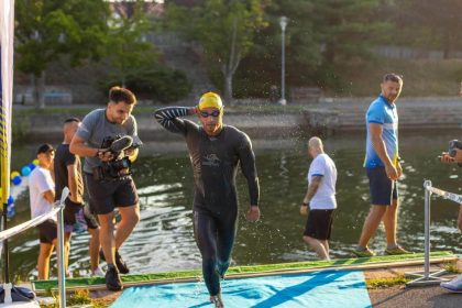 Sportivi concurând la probele de înot pe Bega, ciclism pe bulevarde și alergare în zona centrală, în cadrul evenimentului Timișoara Triathlon.