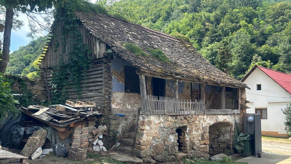 Echipă de specialiști și studenți la arhitectură demontând bârnă cu bârnă o casă istorică din Gârliște pentru a fi relocată la Timișoara.