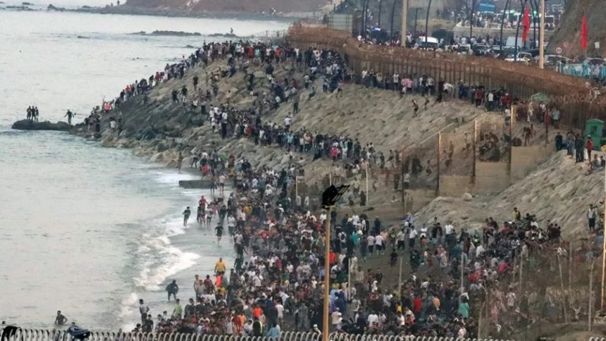 Zeci de mii de migranți au trecut înot din Maroc spre Ceuta, stârnind reacții ferme de la Madrid.