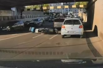 Livrator pe scuter, surprins de o cameră de bord în momentul în care cade pe șosea, sub Pasajul Jiul din Timișoara